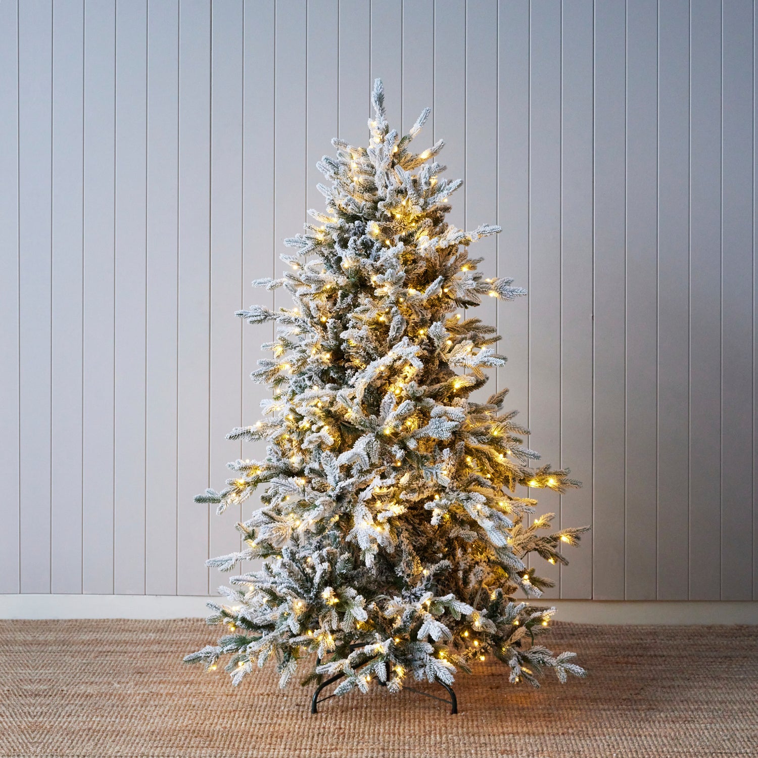 Holly & Ivy flocked Norwegian Christmas tree with warm lights, snowy winter holiday tree decoration